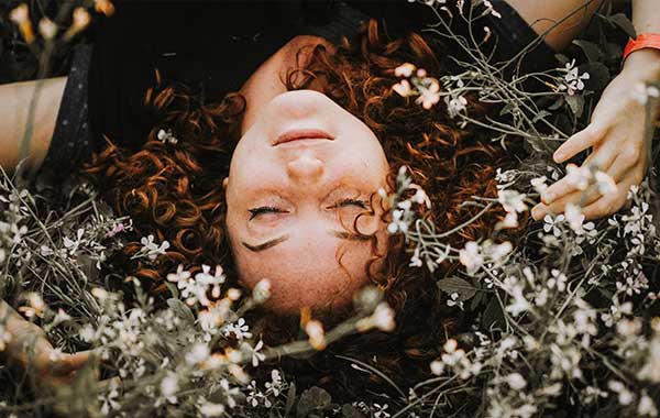 Hiusduetto yhteystiedot, kuvassa nainen niityllä.